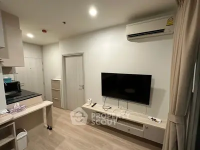 Modern living room with wall-mounted TV and air conditioning in a cozy apartment.