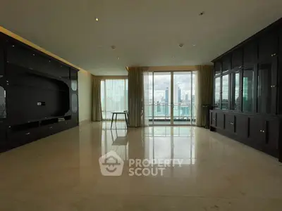 Spacious living room with large windows offering stunning city views and elegant built-in cabinetry.