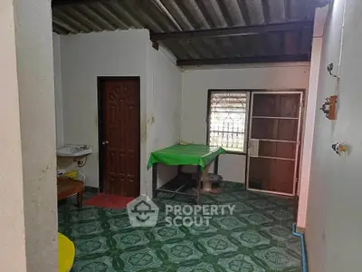 Cozy interior space with green tiled flooring and a small dining area, perfect for compact living.