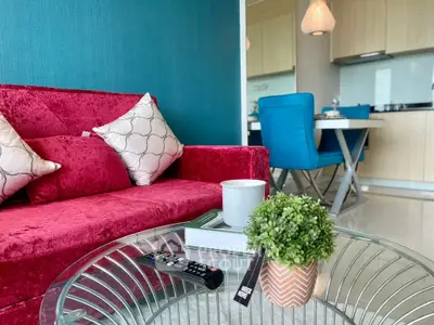 Stylish living room with vibrant red sofa and modern kitchen in open layout