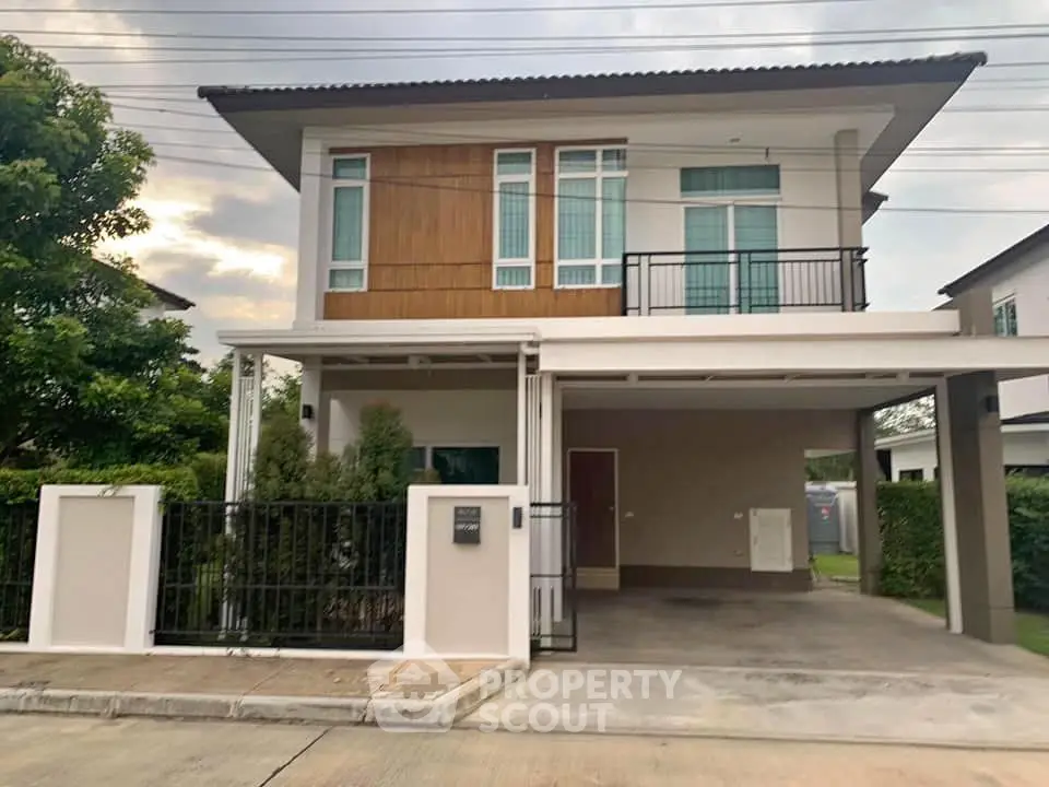 Modern two-story house with carport and landscaped front yard in suburban neighborhood.