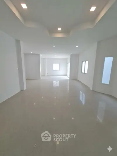 Spacious modern living room with elegant ceiling design and glossy tiled flooring.