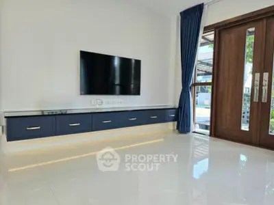 Modern living room with sleek TV unit and elegant wooden doors