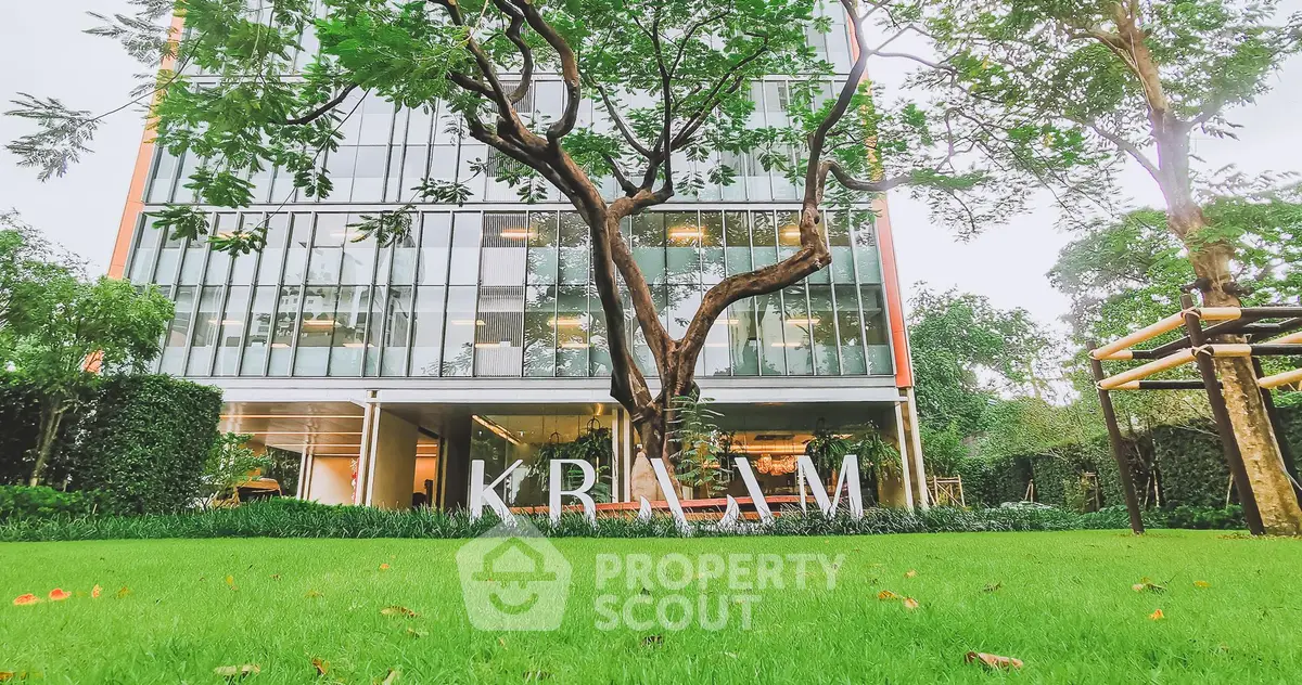 Modern building exterior with lush green garden and large glass windows