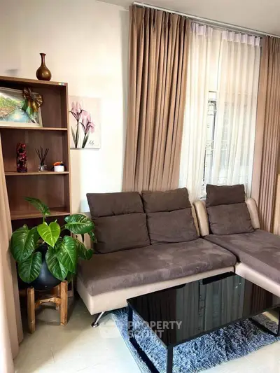 Cozy living room with modern sofa, elegant curtains, and stylish decor for a welcoming ambiance.