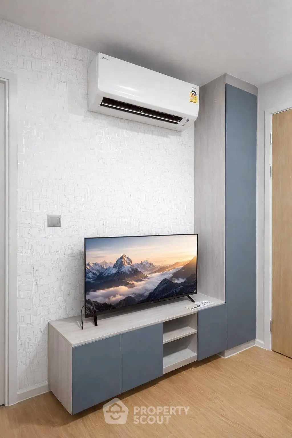 Modern living room with sleek TV unit and air conditioning, perfect for cozy entertainment.