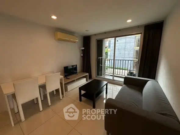 Modern living room with sleek furniture and balcony access