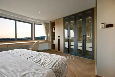 Luxurious bedroom with panoramic window views and elegant wooden flooring