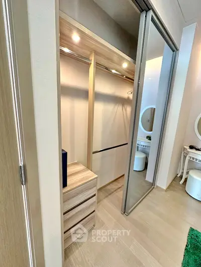 Modern walk-in closet with sliding doors and elegant vanity area in a stylish apartment.