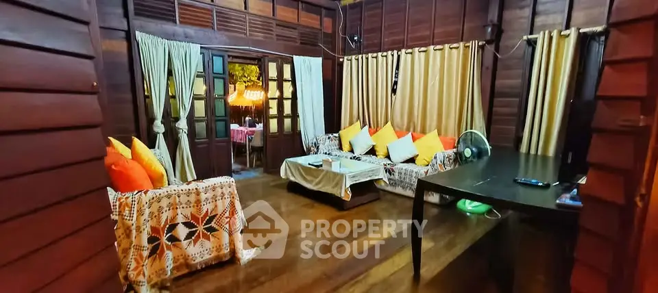 Charming rustic living room with wooden walls and cozy seating area, perfect for relaxation.