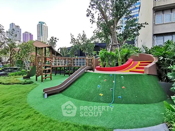 Vibrant outdoor playground in modern residential complex with lush greenery and city skyline views.