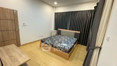 Modern bedroom with stylish bed and wooden flooring, featuring sleek curtains and minimalistic decor.