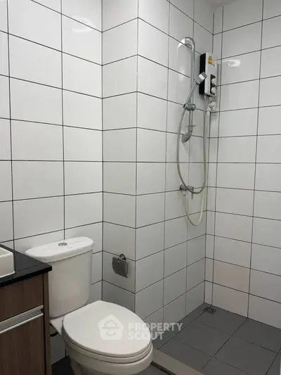 Modern bathroom with sleek white tiles and shower in contemporary apartment.