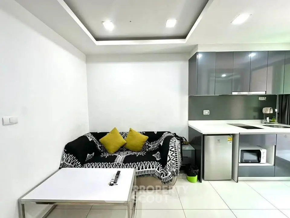 Modern living room with sleek kitchen, cozy sofa, and stylish decor