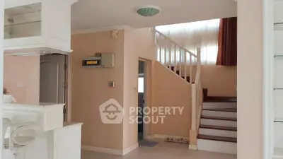 Spacious interior with elegant staircase and modern kitchen area, perfect for family living.