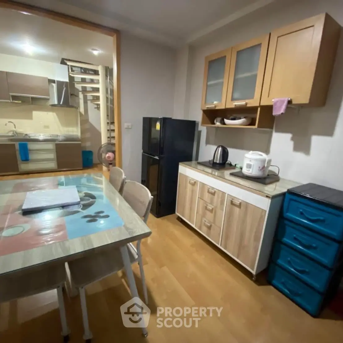 Cozy kitchen with modern appliances and dining area in stylish apartment.