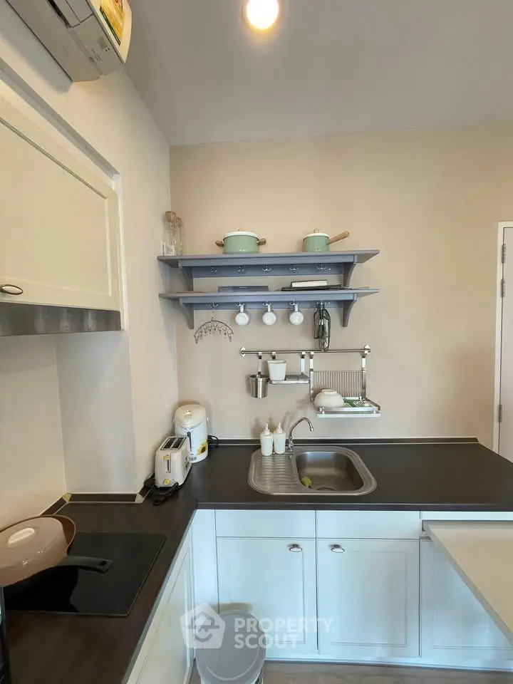 Modern kitchen with sleek design, featuring induction cooktop and stylish shelving.