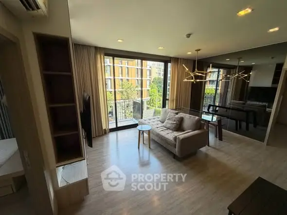Spacious modern living room with large windows and stylish lighting in a luxury apartment.