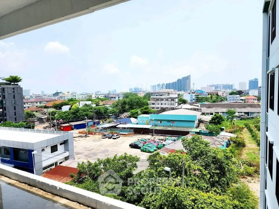 Stunning cityscape view from a modern apartment balcony, showcasing urban skyline and greenery.