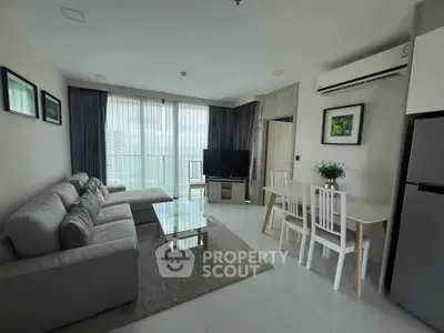 Modern living room with balcony view, stylish furniture, and dining area in a bright apartment.