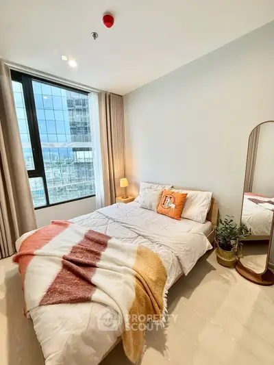 Modern bedroom with large window and stylish decor in high-rise apartment