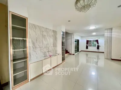 Spacious living room with elegant marble accents and large windows for natural light.