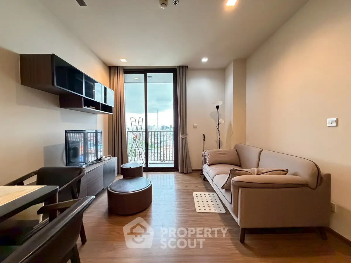 Modern living room with stylish furniture and balcony view in a contemporary apartment.