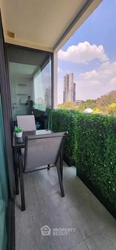 Charming balcony with lush greenery and stunning city view, perfect for relaxation and enjoying the outdoors.