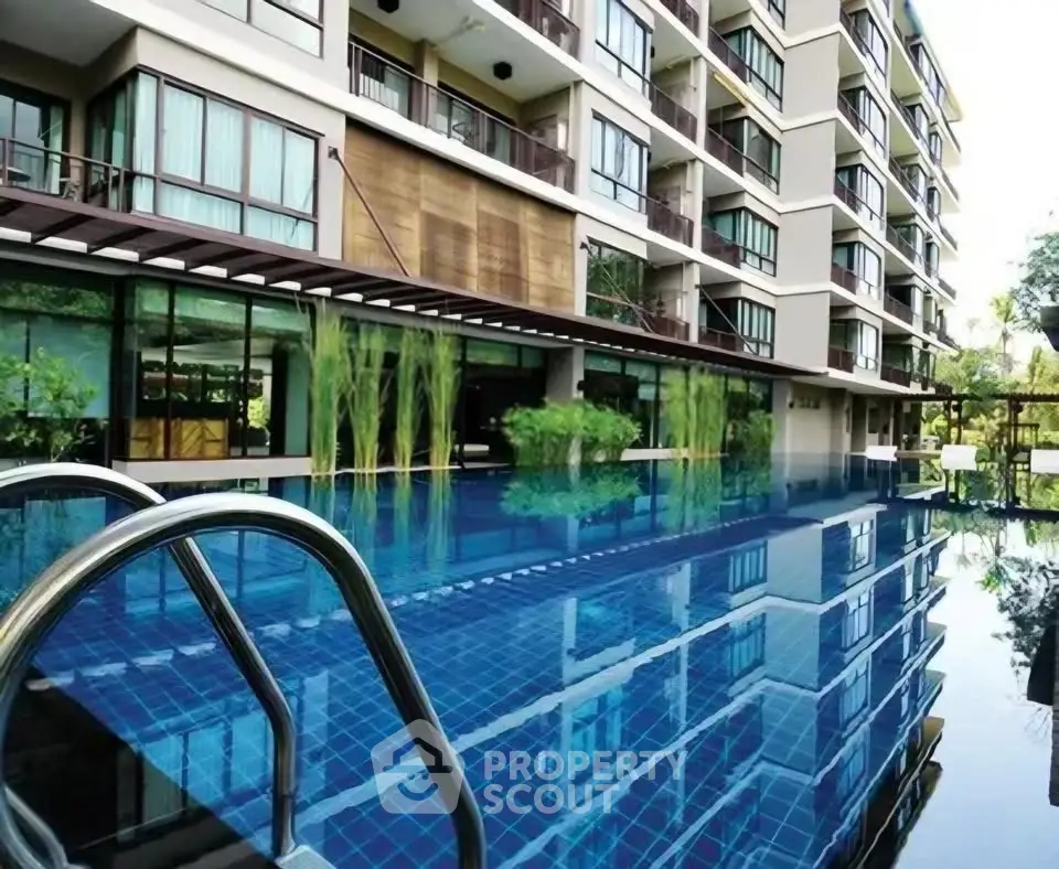 Luxurious apartment complex with stunning poolside view and modern architecture.
