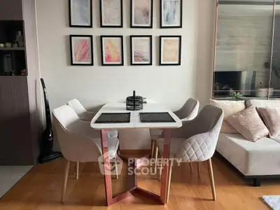Modern dining area with elegant table and chairs, stylish wall art, and cozy living room setup.