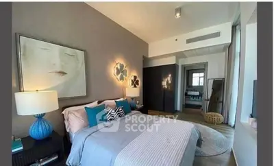 Modern bedroom with stylish decor and cozy ambiance, featuring elegant lighting and contemporary artwork.