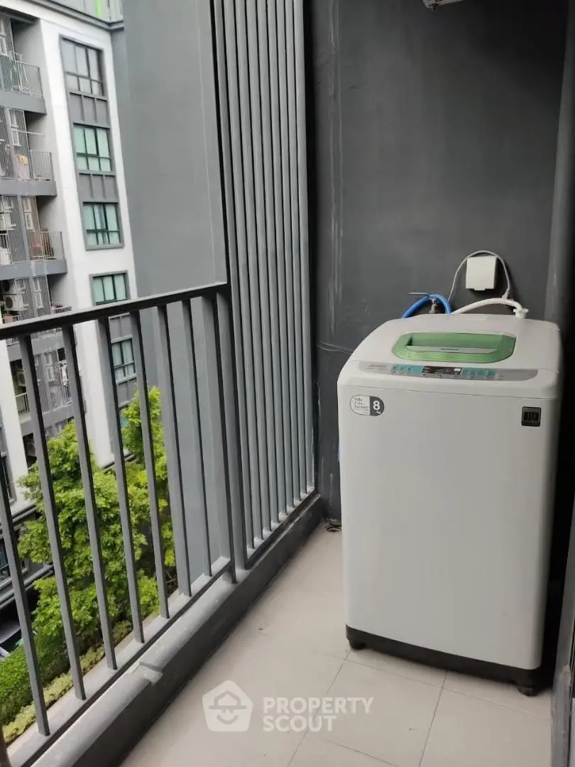 Compact balcony with washing machine in modern apartment building