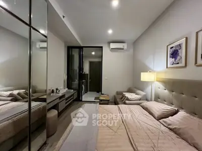 Modern bedroom with elegant decor and mirrored wardrobe in a cozy apartment.
