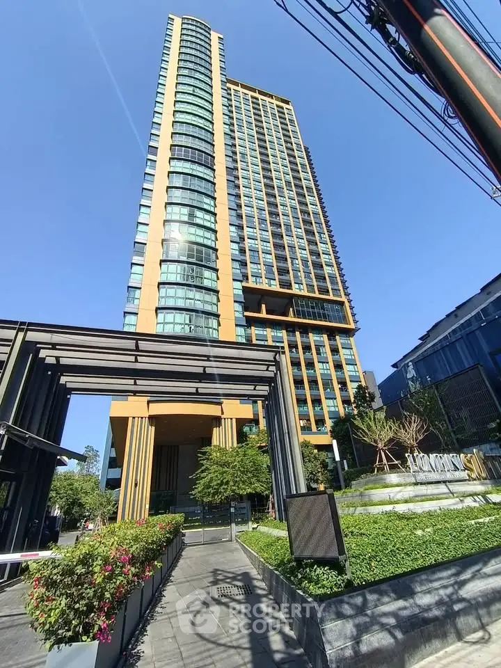 Stunning modern high-rise building with lush landscaping and sleek architectural design.