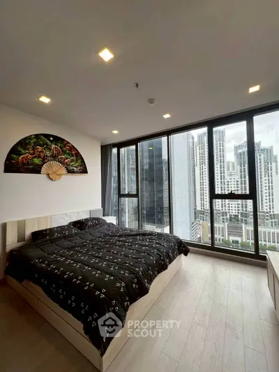 Modern bedroom with large windows offering stunning city view, featuring stylish decor and cozy ambiance.