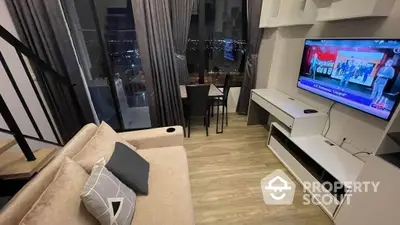 Modern living room with plush sofa, flat-screen TV, and dining area, boasting a stunning night city view through floor-to-ceiling windows.