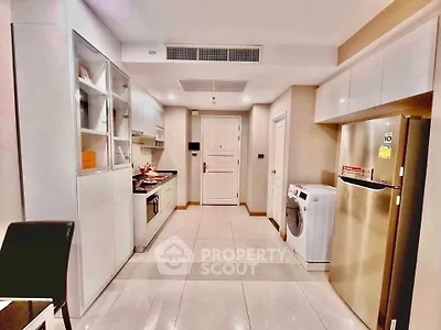 Modern kitchen with sleek appliances and ample storage in a stylish apartment.