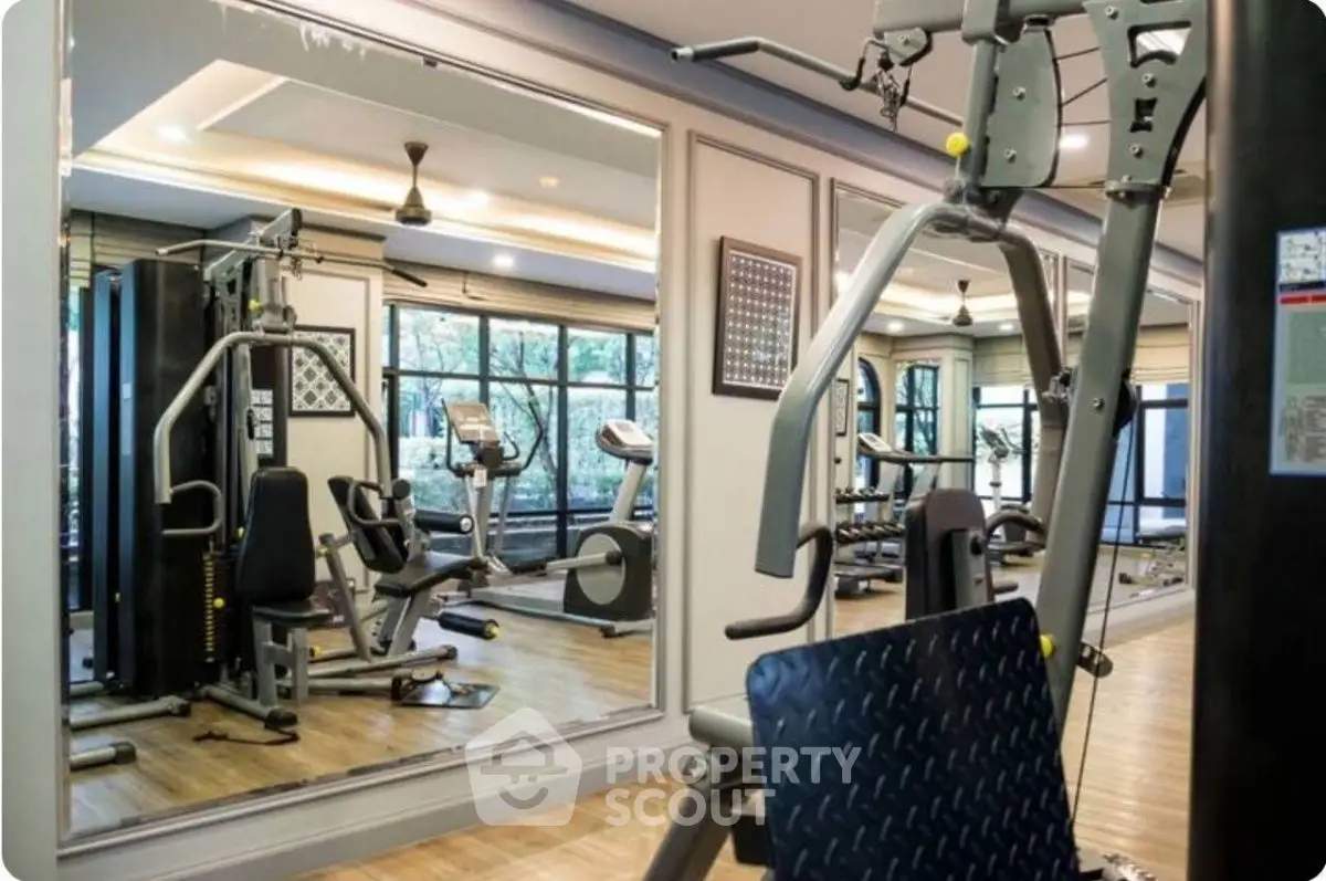 Modern gym with state-of-the-art equipment and mirrored walls in a luxury residential building.