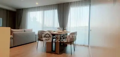 Modern living room with dining area and large windows in a stylish apartment.
