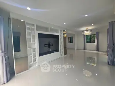 Spacious modern living room with elegant chandeliers and built-in entertainment unit