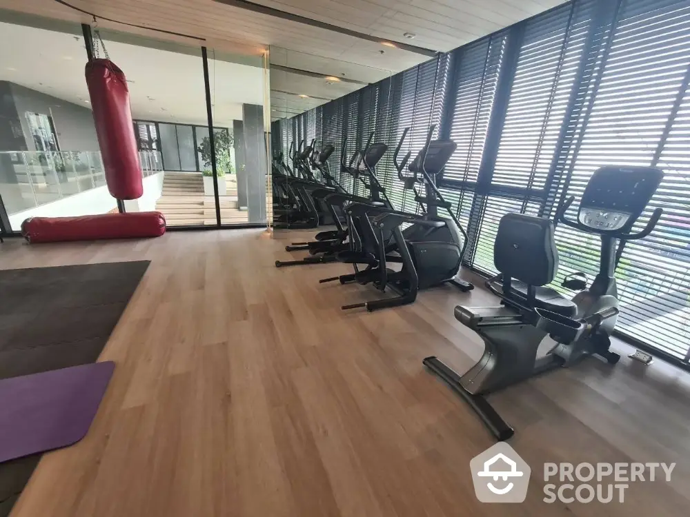 Modern gym with exercise bikes and punching bag in luxury apartment complex