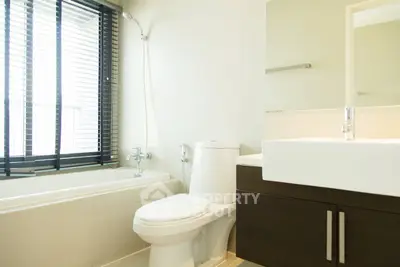 Modern bathroom with sleek fixtures and natural light from large window.