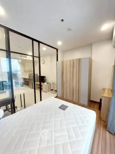 Modern bedroom with glass partition and stylish wardrobe in a contemporary apartment.