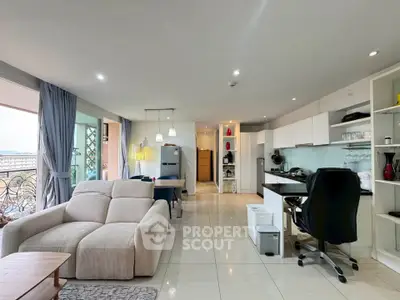 Spacious open-plan living room with modern kitchen and balcony view