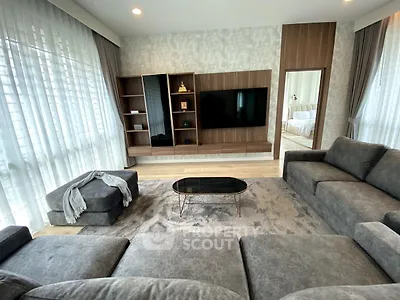 Spacious modern living room with elegant gray sofas and large TV, perfect for relaxation.