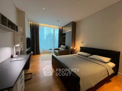 Luxurious bedroom with modern decor, spacious layout, and city view, featuring a cozy seating area and work desk.