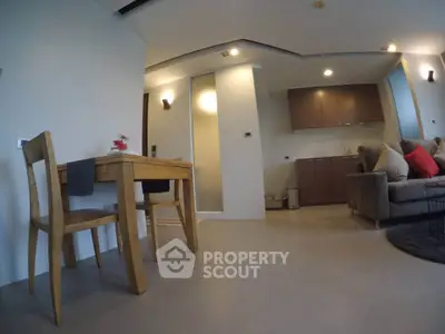 Modern open-plan living room with cozy seating and dining area in a stylish apartment.