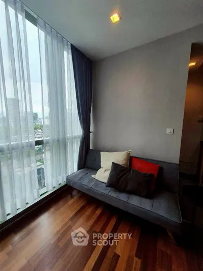 Stylish corner unit with floor-to-ceiling windows and cozy seating area.