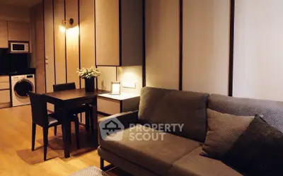 Modern living room with cozy sofa and dining area, featuring sleek design and warm lighting.