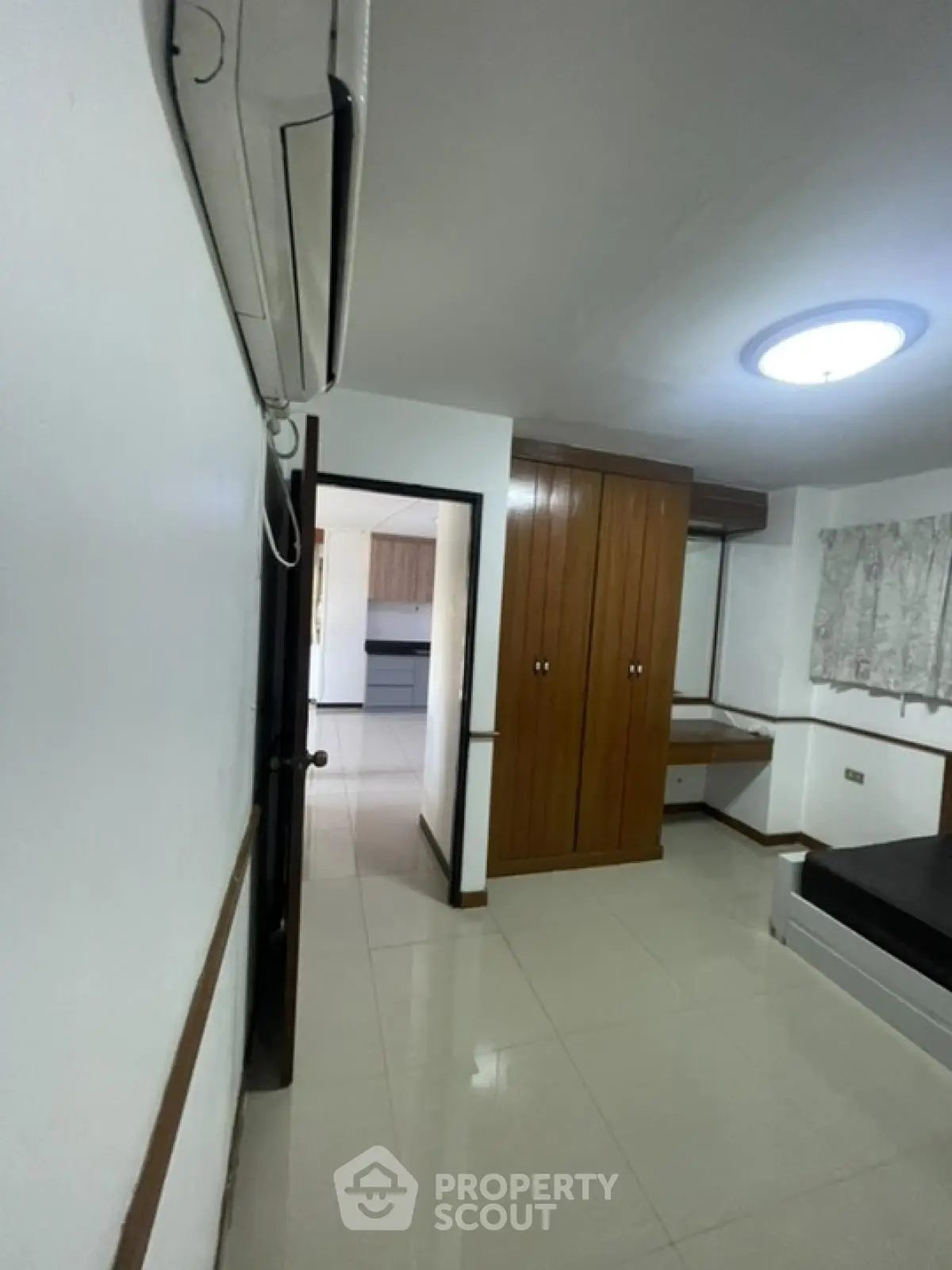 Spacious bedroom with built-in wardrobe and air conditioning in modern apartment